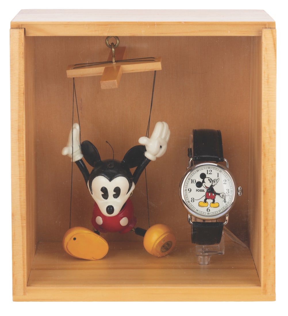 A Mickey Mouse Fossil Watch with Mini-Marionette.: (Fossil, 1997) A Mickey Mouse watch with a miniature marionette and wooden display case, released in a limited edition of 5,000. The case has a laser-etched Mickey & Co. logo on each side. Measuring 4
