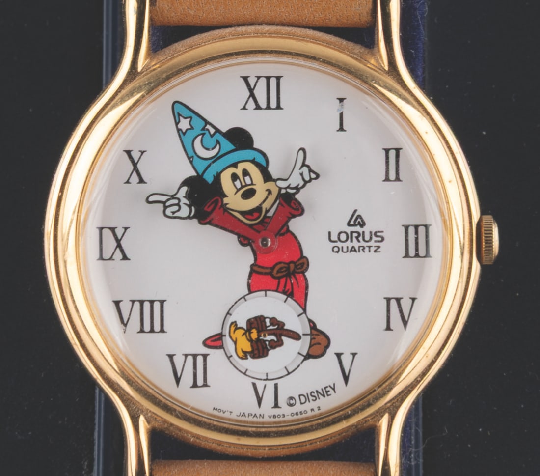 A Sorcerer Mickey Lorus Watch.: (Lorus, 1990s) A Mickey Mouse Sorcerer's Apprentice watch, with a rotating broom as the seconds feature. The watch is in as-new fine condition, requiring a battery and possibly service to function.