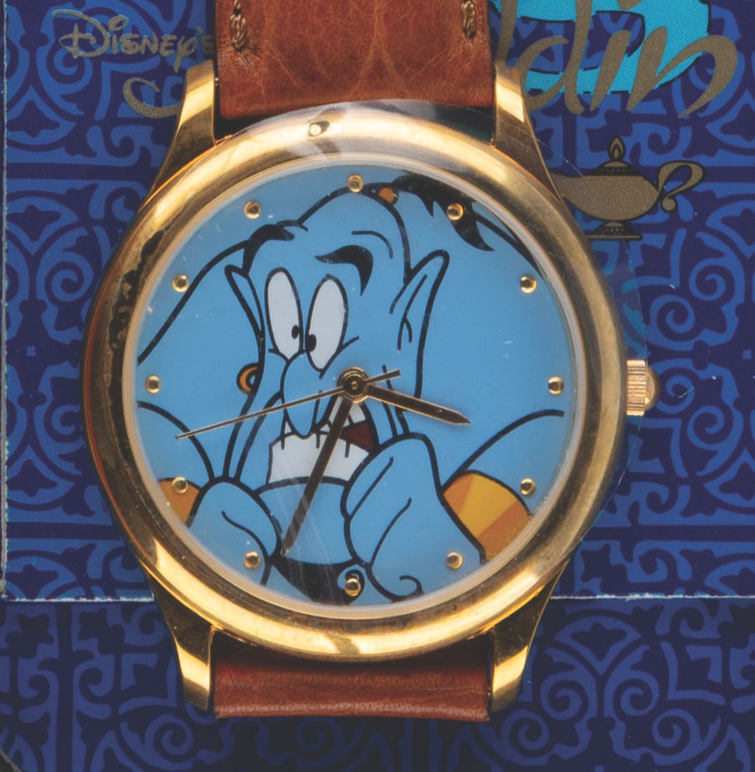 An "Aladdin" Wristwatch with Tin Case.: (Disney, 1992) An "Aladdin" wristwatch featuring the Genie in its original tin case. Measuring 1.5" in diameter with a 9" band, the watch is in fine, as-new condition, requiring a battery and