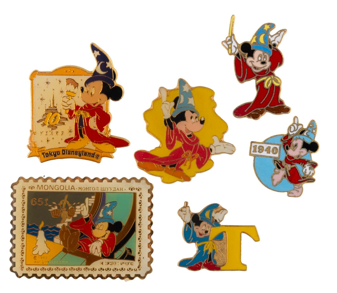 A Collection of Sorcerer Mickey Enamel Pins.: (Disney, 1980s-90s) A collection of six early Sorcerer Mickey pins including a Tokyo Disneyland pin and Mongolia stamp pin. The pins are in very good condition with light handling wear and typical col