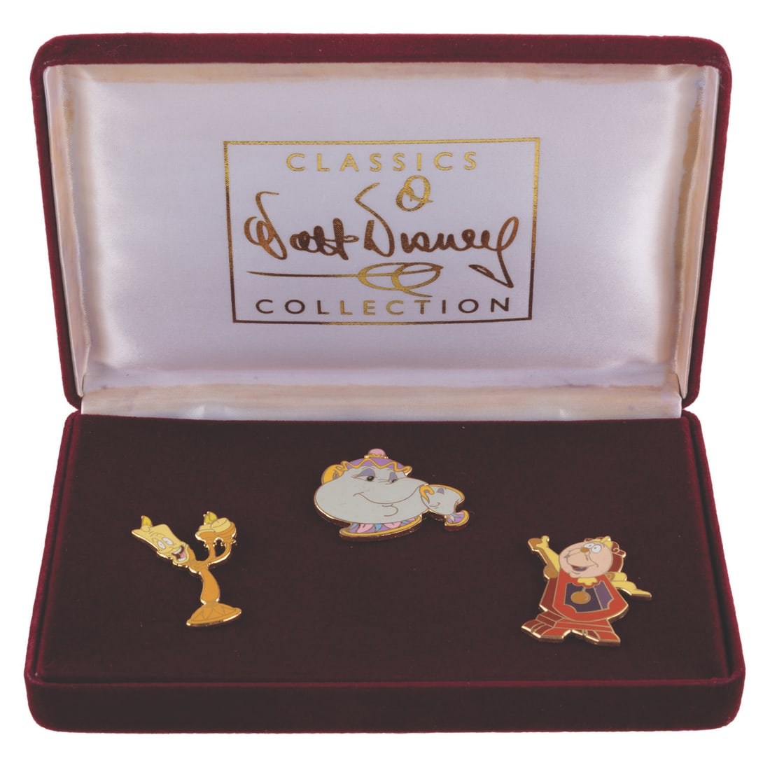 A WDCC "Beauty and the Beast" Pin Set.: (WDCC, 2001) A Walt Disney Classics Collection three-pin set of Lumiere, Cogsworth, and Mrs. Potts with Chip from "Beauty and the Beast," given as a gift with the purchase of the Belle "Dreaming of a