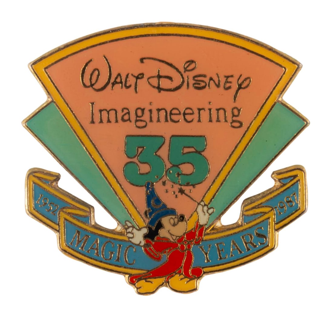 A Walt Disney Imagineering 35th Anniversary Pin.: (Disney, 1987) A pin celebrating the 35th anniversary of Walt Disney Imagineering in 1987. Measuring 1.5" x 1.75", the is in very good condition with typical color shift from age.