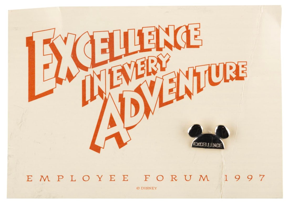 A Disney Employee Forum Pin and Card.: (Disney, 1997) A Mickey Ears pin and card from the 1997 Disney "Excellence in Every Adventure" Employee Forum. Measuring 3.25" x 5", the pin and card are in good condition with creasing and smudging.