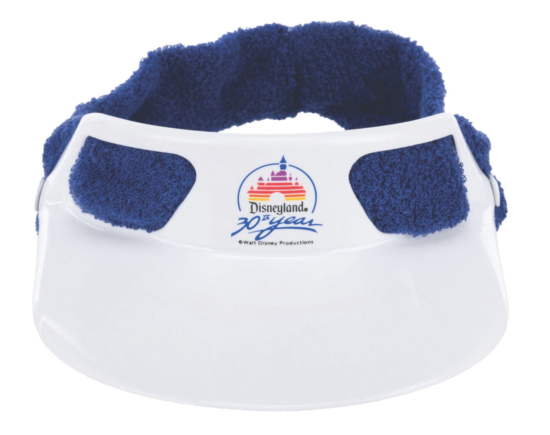 A Disneyland 30th Anniversary Visor.: (Disneyland, 1985) A white visor with blue trim commemorating the 30th Anniversary of Disneyland. The Disneyland logo with Sleeping Beauty Castle is present. The visor is in fine unused condition.