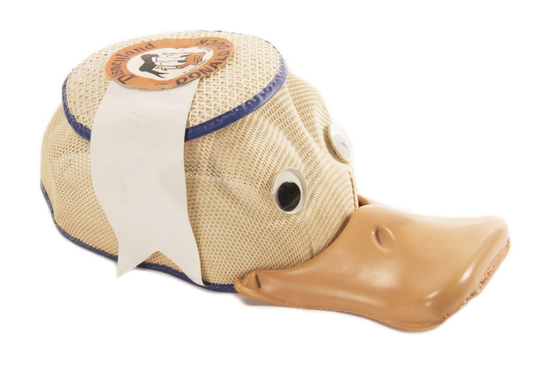 A Disneyland Souvenir Donald Duck Squeaker Hat.: (Benay-Albee, 1950s-60s) An early Donald Duck child's hat with a working squeaker in its bill. Measuring a size "small," this hat retains its original Disneyland patch on the top and is in good