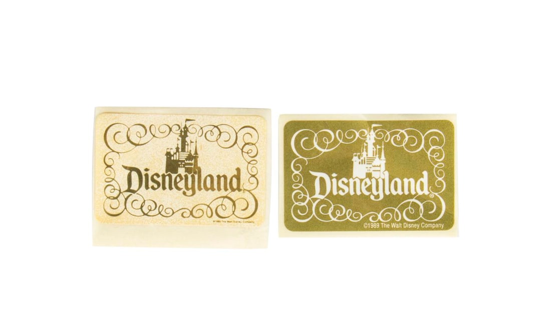 A Pair of Disneyland Castle Logo Product Stickers.: (Disneyland, 1989) A pair of product stickers from one of Disneyland's Main Street souvenir shops. The stickers feature Sleeping Beauty Castle above the name "Disneyland," and both have a 1989