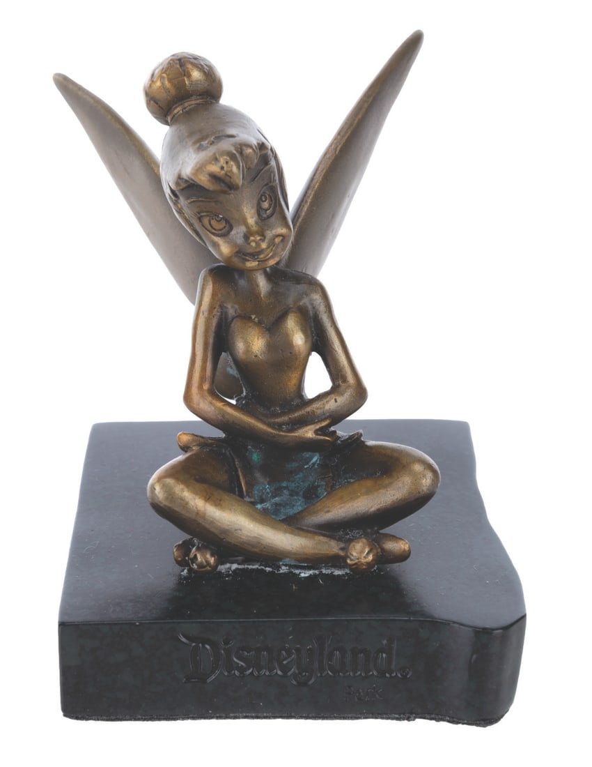 A Disneyland Souvenir Bronze Tinker Bell.: (Disneyland, 1980s-90s) A bronze-colored figurine of Tinker Bell on a marble base etched with "Disneyland." Measuring 3" x 3.5" x 3.5" high, the figure is in good condition with spots of verdigris