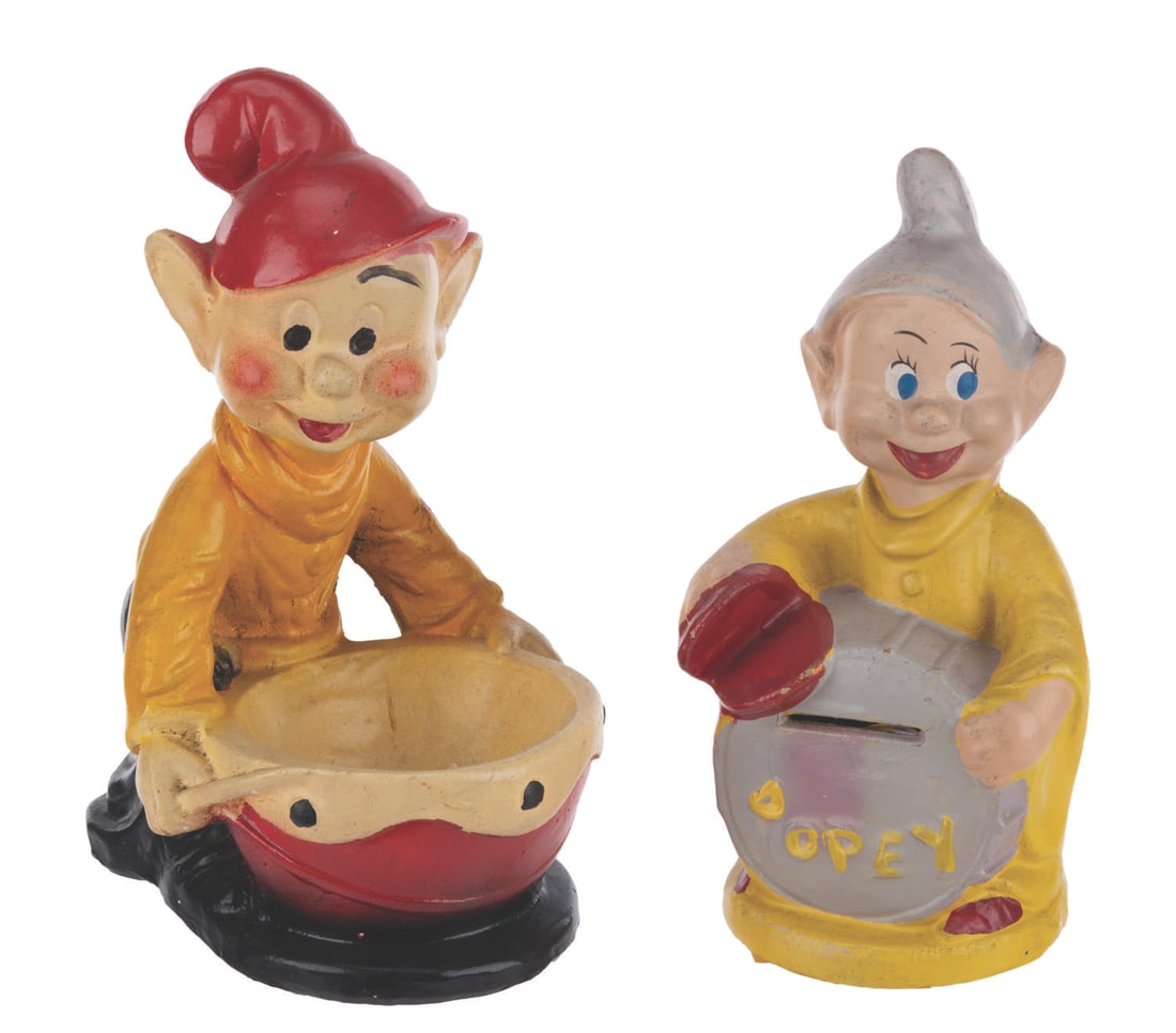 A "Snow White" Dopey Bank and Trinket Dish.: (Disney, 1930s-50s) A composite Dopey bank by Walt Disney Enterprises and a ceramic Dopey trinket dish. Ranging in size from 3.25" and 7.25" in diameter to 6" x 4.5" x 8" tall, the "Snow White and the
