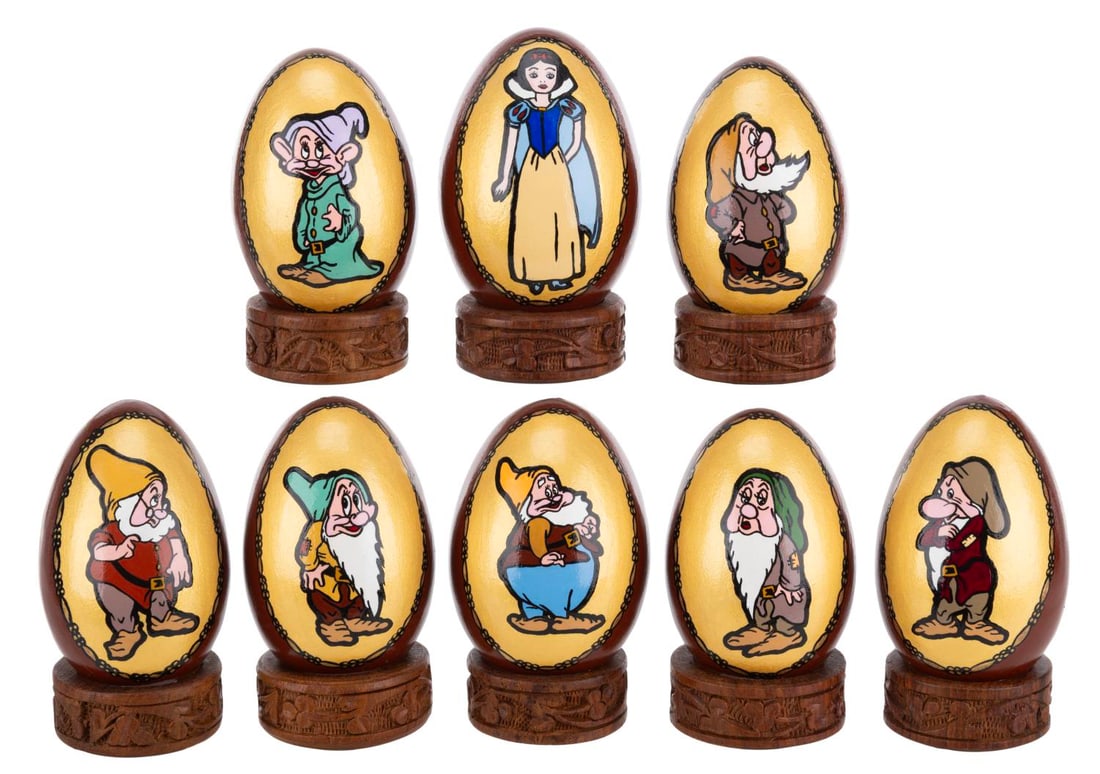 A "Snow White and the Seven Dwarfs" Egg Set.: (Disney, 1950s-70s) A collection of eight hand-painted egg-shaped collectibles featuring the lead characters from "Snow White and the Seven Dwarfs." Measuring 3.25" tall and 4" tall including their