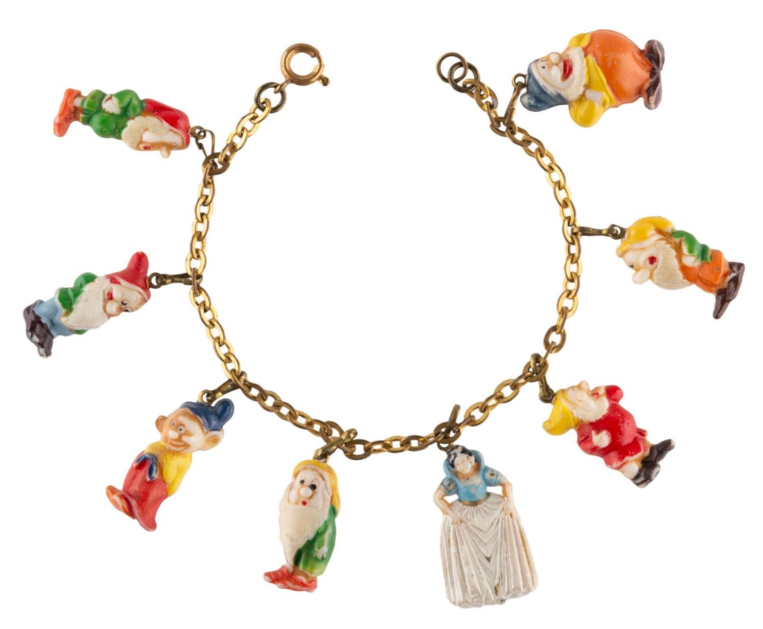 An Early "Snow White" Charm Bracelet.: (Disney, 1930s) An early "Snow White and the Seven Dwarfs" charm bracelet with hand-painted plastic characters on a gold-toned metal chain. Measuring 7" long, the bracelet is in good condition with pa