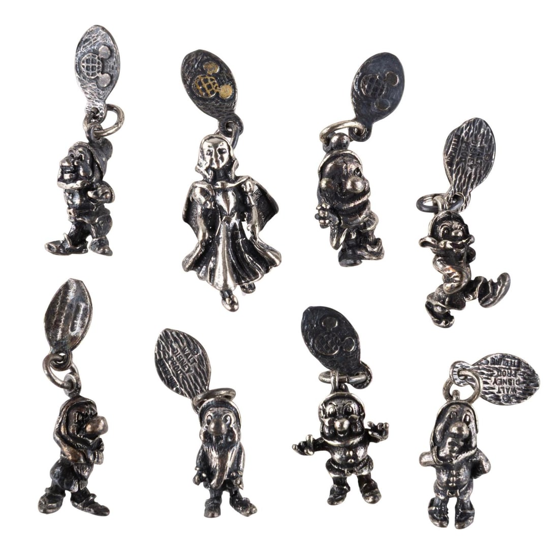 A Set of "Snow White" Silver Character Charms.: (Disneyland/ Walt Disney World, 1970s-80s) An eight-piece sterling silver "Snow White and the Seven Dwarfs" character charm set. Included are all seven dwarfs and Snow White. Seven of the pieces have 