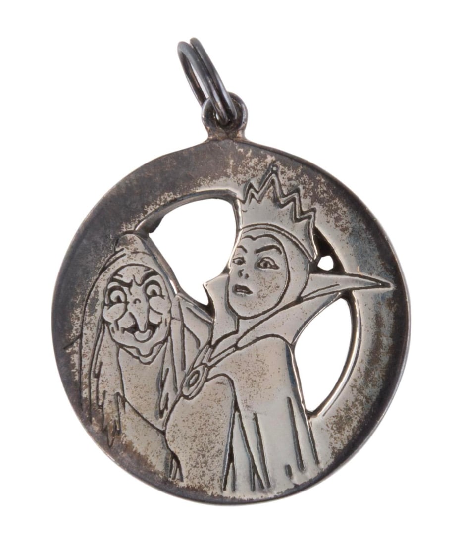A Silver "Snow White" Evil Queen Pendant.: (Disney, 1990s) A pierced sterling silver "Snow White and the Seven Dwarfs" Evil Queen and Old Hag pendant. Measuring 1" across the pendant is in good condition with heavy tarnishing.