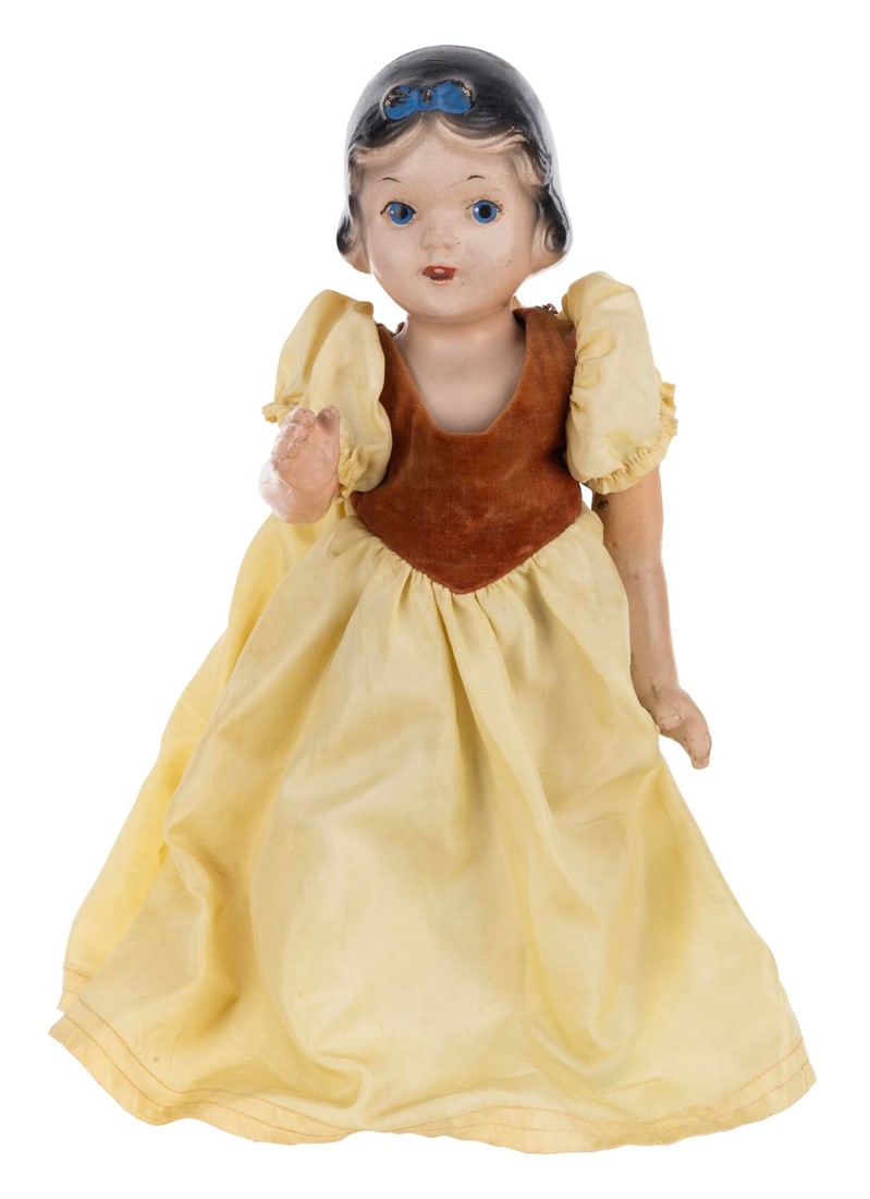 A Snow White Doll in Madame Alexander Dress.: (1930s) A composition doll of Snow White in a Madame Alexander dress. Measuring 13" tall, the doll consists of a head, torso, and right arm and is in poor condition with paint loss, scratches,