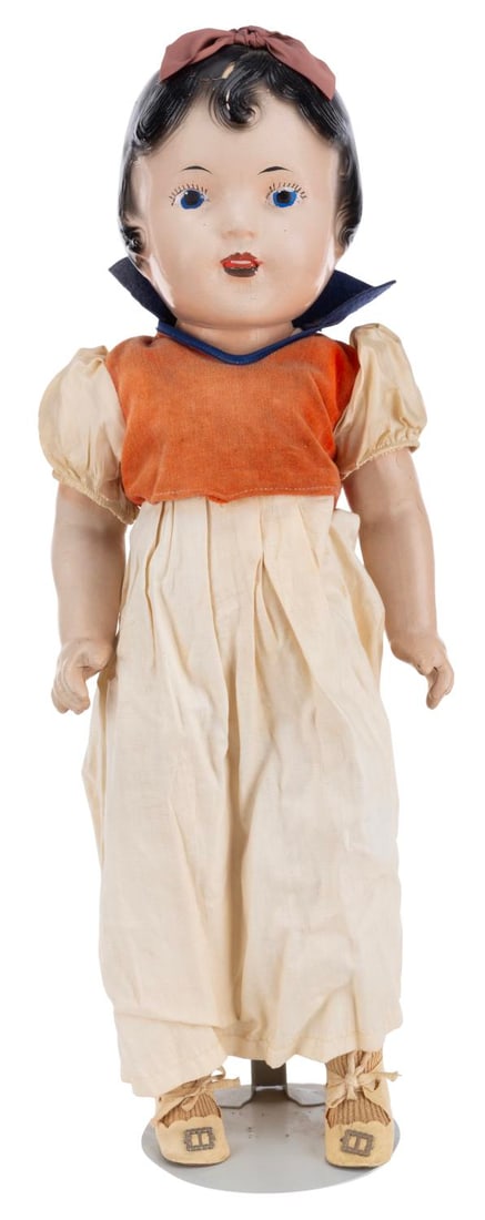 A Snow White Composition Doll.: (1930s) An early composition doll of Snow White on a metal stand. Measuring 15" tall, the doll is in poor condition with cracks, scuffs, wear, discoloration from age, material loss, and the head is
