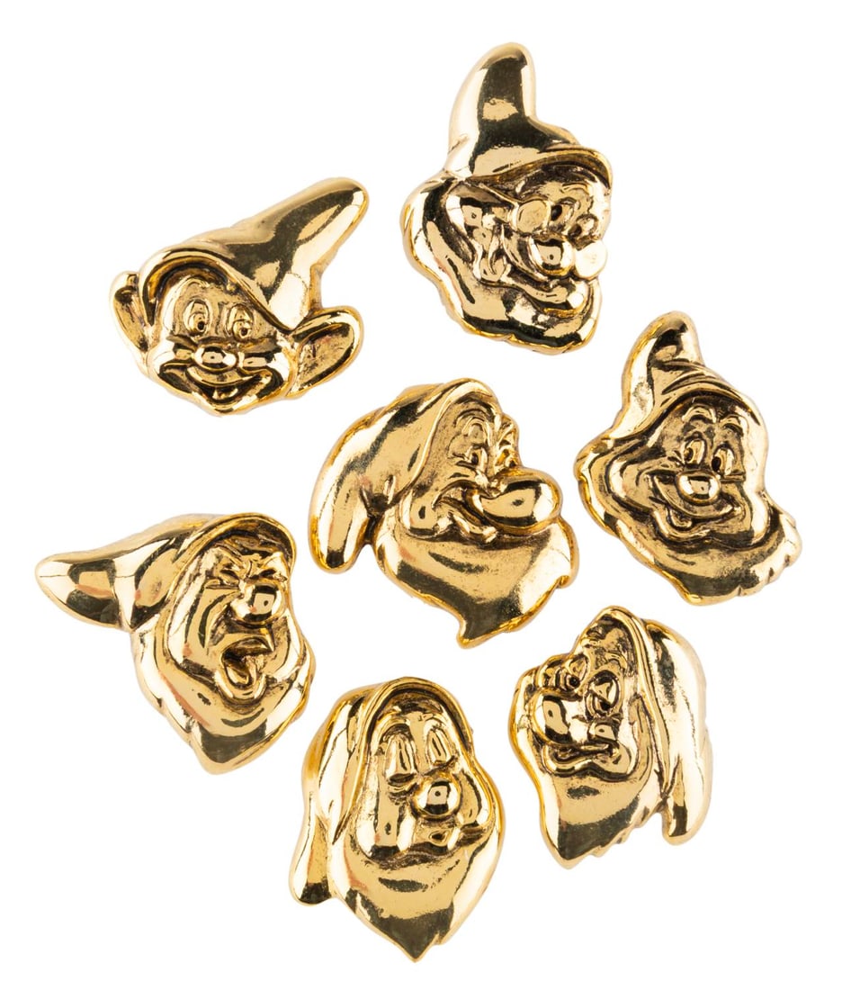 A Set of Gold "Snow White" Dwarf Pins.: (Disney Store, 1980s-90s) A seven-piece gold-toned pin set of each Dwarf from "Snow White and the Seven Dwarfs." Measuring approximately 1" tall each, the set is in very good condition with light