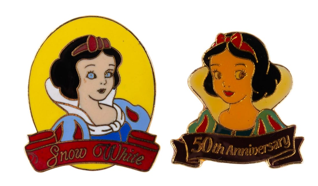 A Pair of Snow White Pins.: (Disney, 1987-90s) A pair of Snow White pins, including a 50th Anniversary pin and an "Oval Princess." The pins are in good condition with light discoloration and soiling.