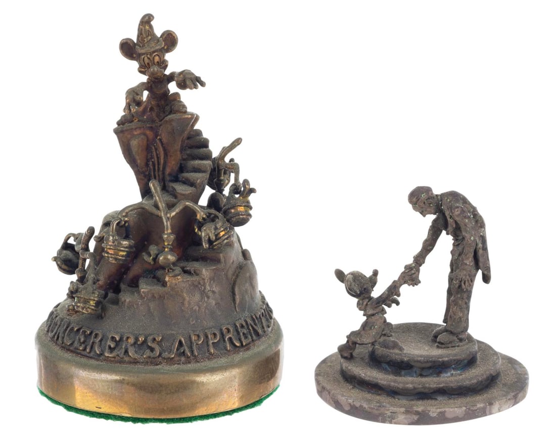 A Pair of Miniature "Fantasia" Bronze and Silver Statues.: (Disney, 1970s-80s) A pair of miniature statues from "Fantasia," including a sterling silver statue of Mickey shaking Stokowski's hand and another bronze statue of the Sorcerer's Apprentice scene.