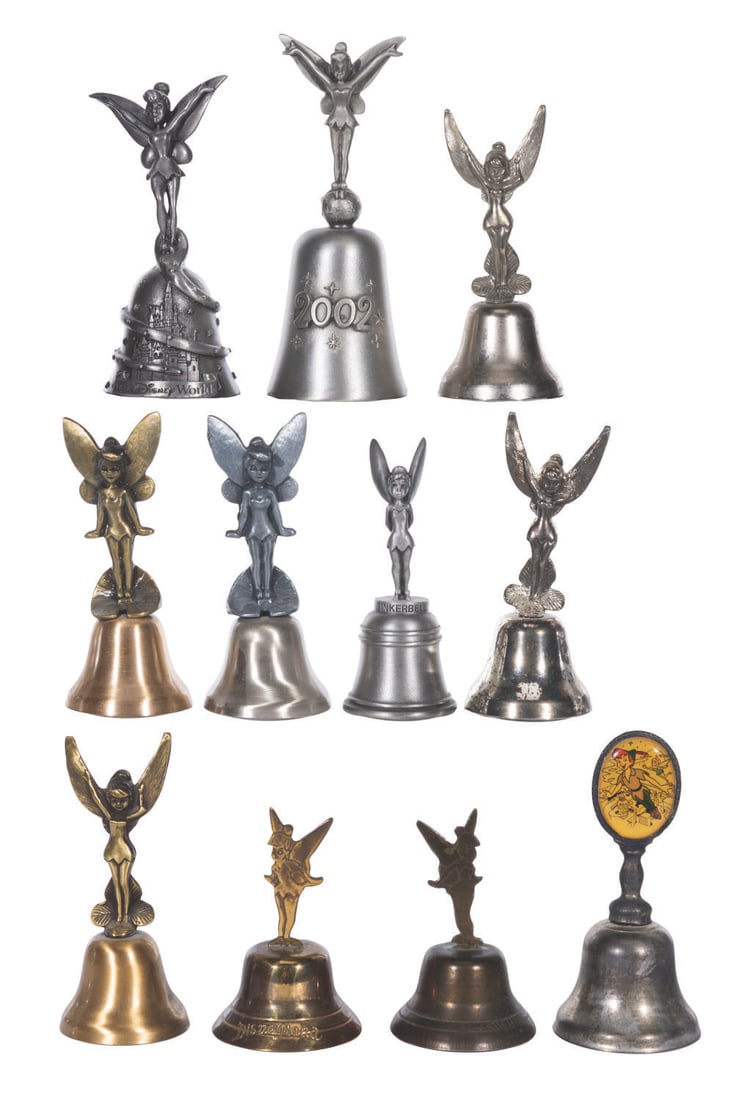 A Collection of 11 Metal Tinker Bell Bells.: (Various, 1950s-2000) A collection of 11 metal Tinker Bell bells, including bells from Disneyland, Walt Disney World, the New England Collectors Society, and Schmid. Measuring 2.5" to 3.75" tall, the 