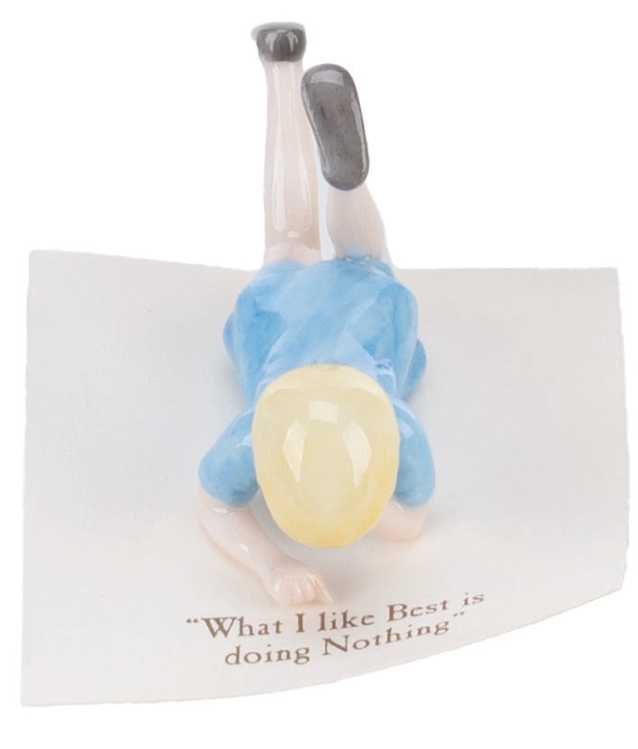 A Mini "Winnie the Pooh" Christopher Robin Figurine.: (Michel and Co., 1990s) A mini ceramic figurine of Christopher Robin, inspired by the original illustrations for the Winnie the Pooh books by E. H. Shepard. The figure is attached to a card with a