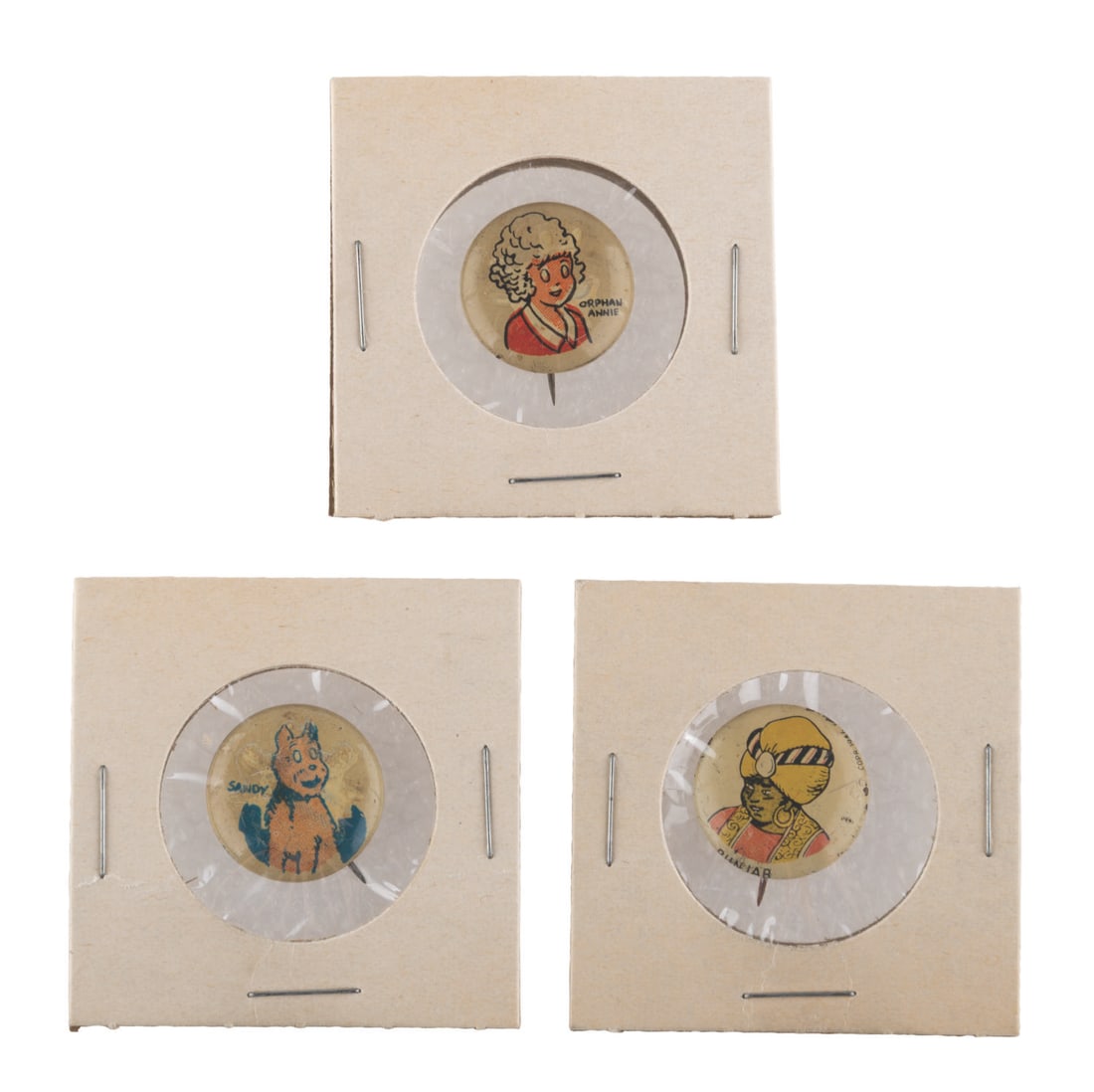 A Trio of "Little Orphan Annie" Kellogg's PEP Pins.: (Kellogg's, 1940s) Three Kellogg's PEP pins featuring characters from the comic strip Little Orphan Annie. Included are Annie, Sandy, and Punjab. The pins are in good condition with some fading from