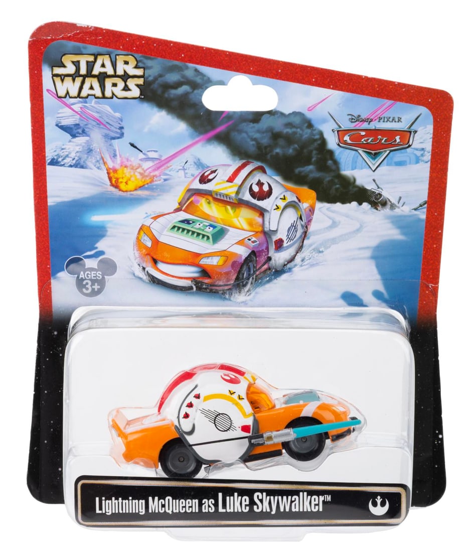 A Cars/Star Wars Lightning McQueen as Luke Skywalker Toy.: (Disney, 2013) A toy of Lightning McQueen from "Cars" as Luke Skywalker. Measuring 3" long the toy is in fine condition on the original card. The card is very good condition with a small crease to