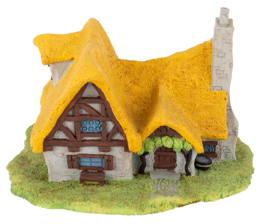 A "Snow White" Cottage Figurine.: (Hudson-Porcelain, 1980s) A hand-painted porcelain figure of the cottage from "Snow White and the Seven Dwarfs." Measuring 7" x 6.5" x 4.5" tall, the figure is in very good condition.