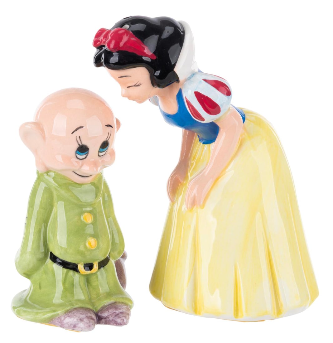 A Snow White and Dopey Salt and Pepper Shaker Set.: (Disney, 2000s) A ceramic salt and pepper shaker set of Snow White and Dopey from "Snow White and the Seven Dwarfs." Measuring 3" to 4" tall, the set is in very good condition with adhesive on the und
