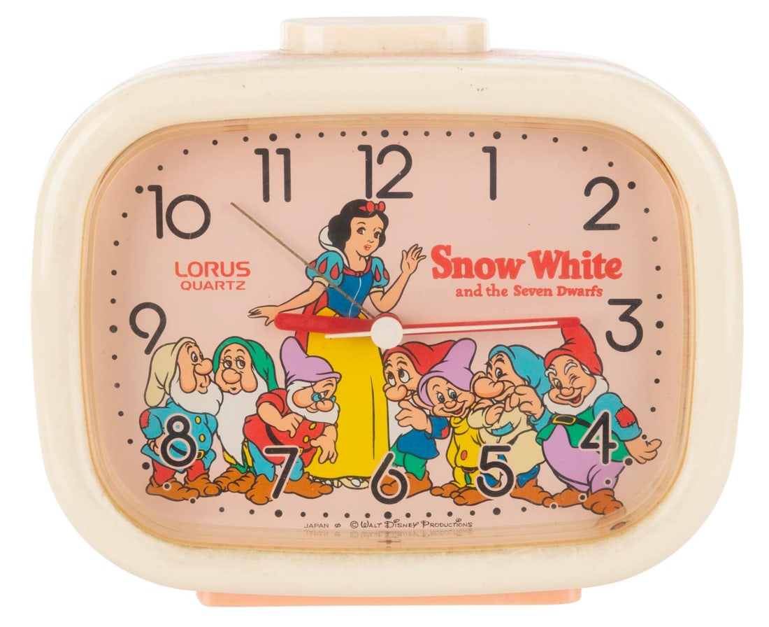 A "Snow White and the Seven Dwarfs" Alarm Clock.: (Lorus, 1980s) A "Snow White and the Seven Dwarfs" Quartz Alarm Clock. The clock operates on one "C" sized battery and is sold as untested and may require service to function. Measuring 2.5" x 5" x