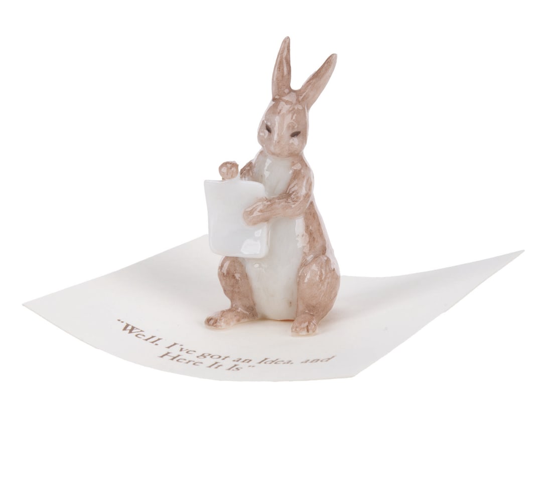 A Mini "Winnie the Pooh" Rabbit Figurine.: (Michel and Co., 1990s) A mini ceramic figurine of Rabbit, inspired by the original illustrations for the Winnie the Pooh books by E. H. Shepard. The figurine is attached to a card with a quote that r
