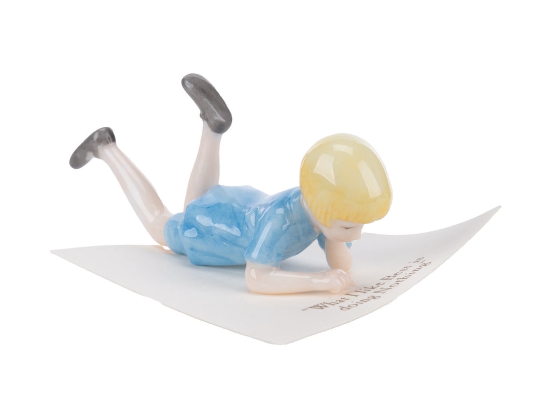 A Mini "Winnie the Pooh" Christopher Robin Figurine.: (Michel and Co., 1990s) A mini ceramic figurine of Christopher Robin, inspired by the original illustrations for the Winnie the Pooh books by E. H. Shepard. The figure is attached to a card with a quo