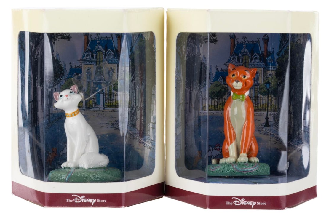 A Pair of "The Aristocats" Tiny Kingdom Figurines.: (Disney Store, 1990s) A pair of "The Aristocats" Tiny Kingdom figurines in the original boxes, including Thomas O'Malley and Duchess. Measuring 3" x 3" x 3.5" in the box, the figures are in fine condi