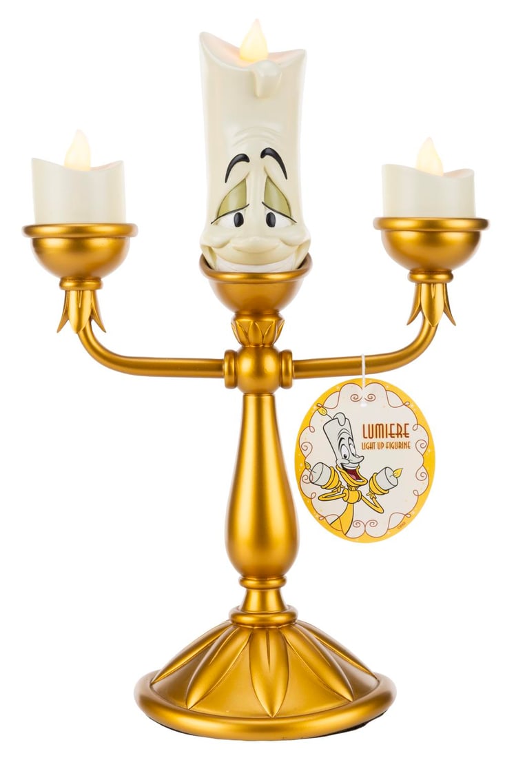 A "Beauty and the Beast" Lumiere Light-Up Figurine.: (Disney Parks, 2000s) A light-up figurine of Lumiere from "Beauty and the Beast." With three "AAA" batteries (not included), Lumiere's candle tips light and flicker, functioning when tested. Measuring