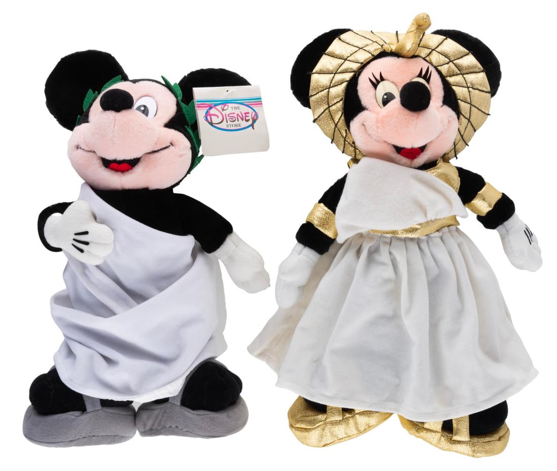 A Pair of Las Vegas Disney Store Roman Minnie and Toga Mickey Plushes.: (Disney, 1990s-2000s) A pair of Roman Minnie and Toga Mickey plushes, sold exclusively at the Disney Store in Las Vegas. Measuring 14" tall each, the plushes have their original tags intact and are in