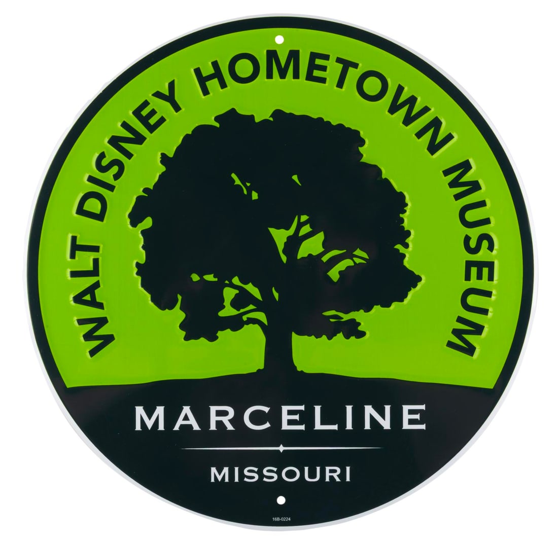 A Walt Disney Hometown Museum Sign.: (WDHM, 2000s) A souvenir tin sign for the Walt Disney Hometown Museum, which opened in Marceline Missouri in 2001. Measuring 11.75" in diameter, the sign is in fine condition.