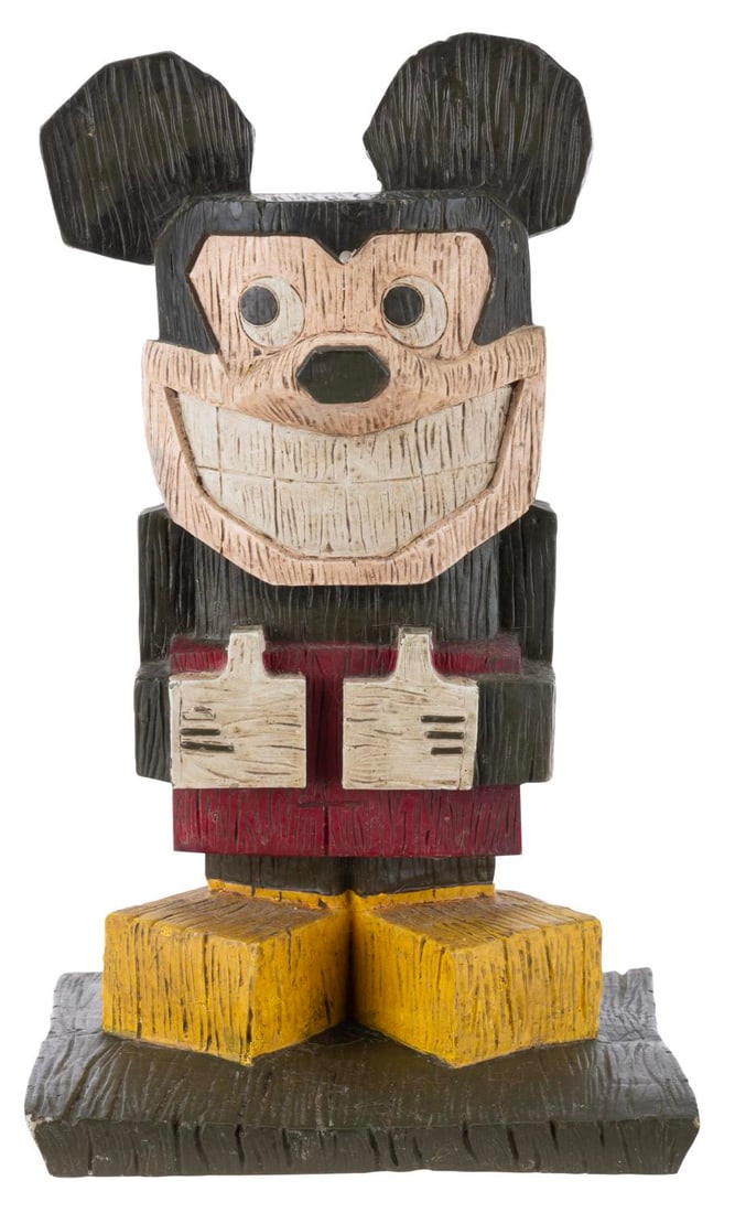 A Mickey Mouse Tiki Statue.: (Disney Store, 2000s) A faux-wood Mickey Mouse Tiki garden statue. Measuring 13" tall, the resin statue is in very good condition with light soiling, spots of paint loss, chips, and intentional distre