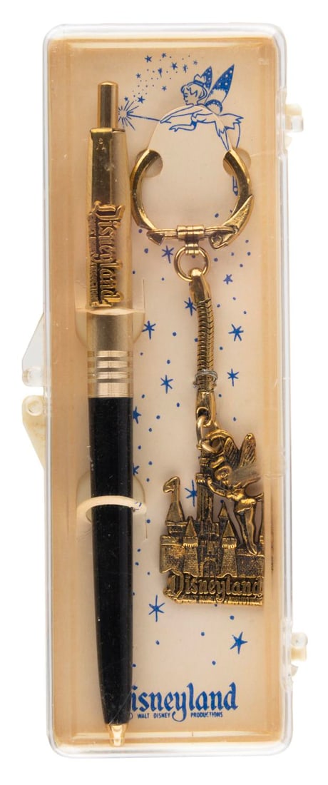 A Disneyland Ballpoint Pen with Tinker Bell Keychain.: (Disneyland, 1960s) A souvenir pen and keychain set from Disneyland in its original plastic case. The case measures 5.5" x 2" and the set displays in fine condition with slight discoloration from age.