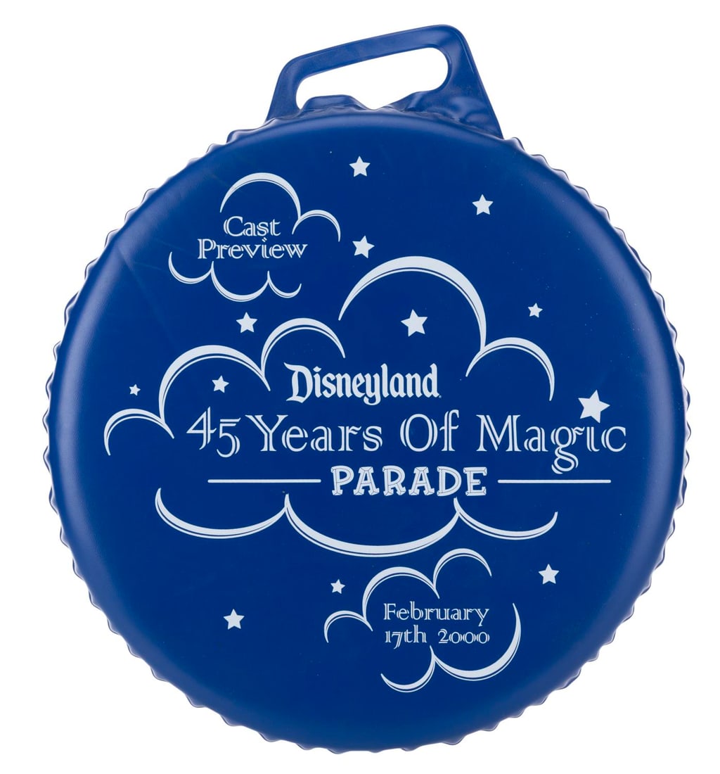 A Disneyland 45 Years Of Magic Cast Parade Cushion.: (Disneyland, 2000) A cushion from the 45 Years of Magic Parade Cast Preview at Disneyland. Measuring 13" across x 2" thick, the cushion is in good condition with light creasing, scuffs, soiling, and
