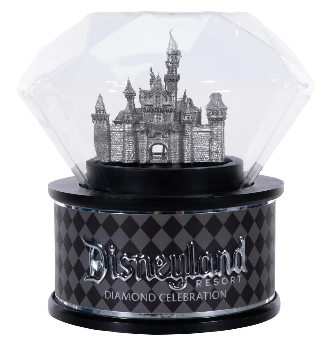 A Disneyland 60th Anniversary Rotating Castle Globe.: (Disneyland, 2015) A Disneyland 60th Anniversary figure featuring a diamond shaped glass globe surrounding an LED lit, rotating Sleeping Beauty Castle. The figure requires 3 "AA" batteries (not includ