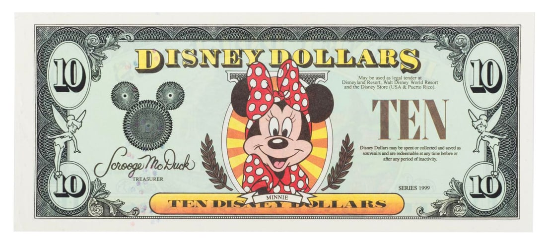 A $10 Series 1999 Disney Dollar.: (Disney, 1999) A $10 Disney Dollar from Series 1999, featuring Minnie Mouse on the front and Disneyland iconography on the reverse. Measuring 2.75" x 6.5", the Disney Dollar displays in very good