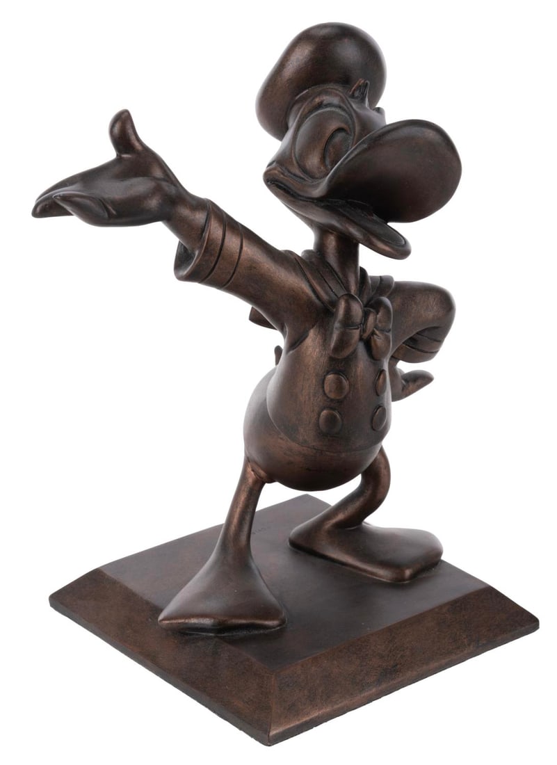 A Bronze Donald Duck Statue.: (Disney, 2000s) A bronze statue of Donald Duck, resembling the statue seen in front of Sleeping Beauty Castle in Disneyland. Measuring 4.75" x 4.75" x 8" tall, the statue is in fine condition.