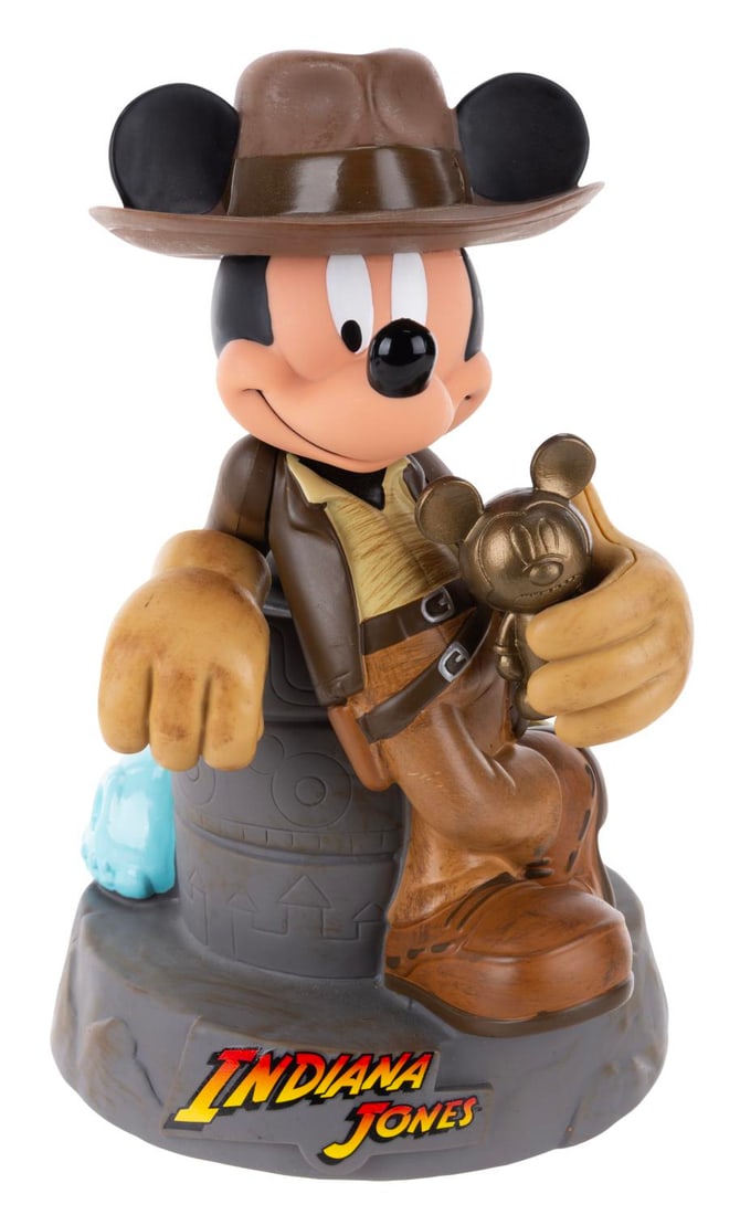 A Mickey Mouse as Indiana Jones Bank.: (Disney/Lucasfilm, 2001) A vinyl bank of Mickey Mouse as Indiana Jones. Measuring 7" diameter x 9.5" tall, the vinyl bank is in fine condition.
