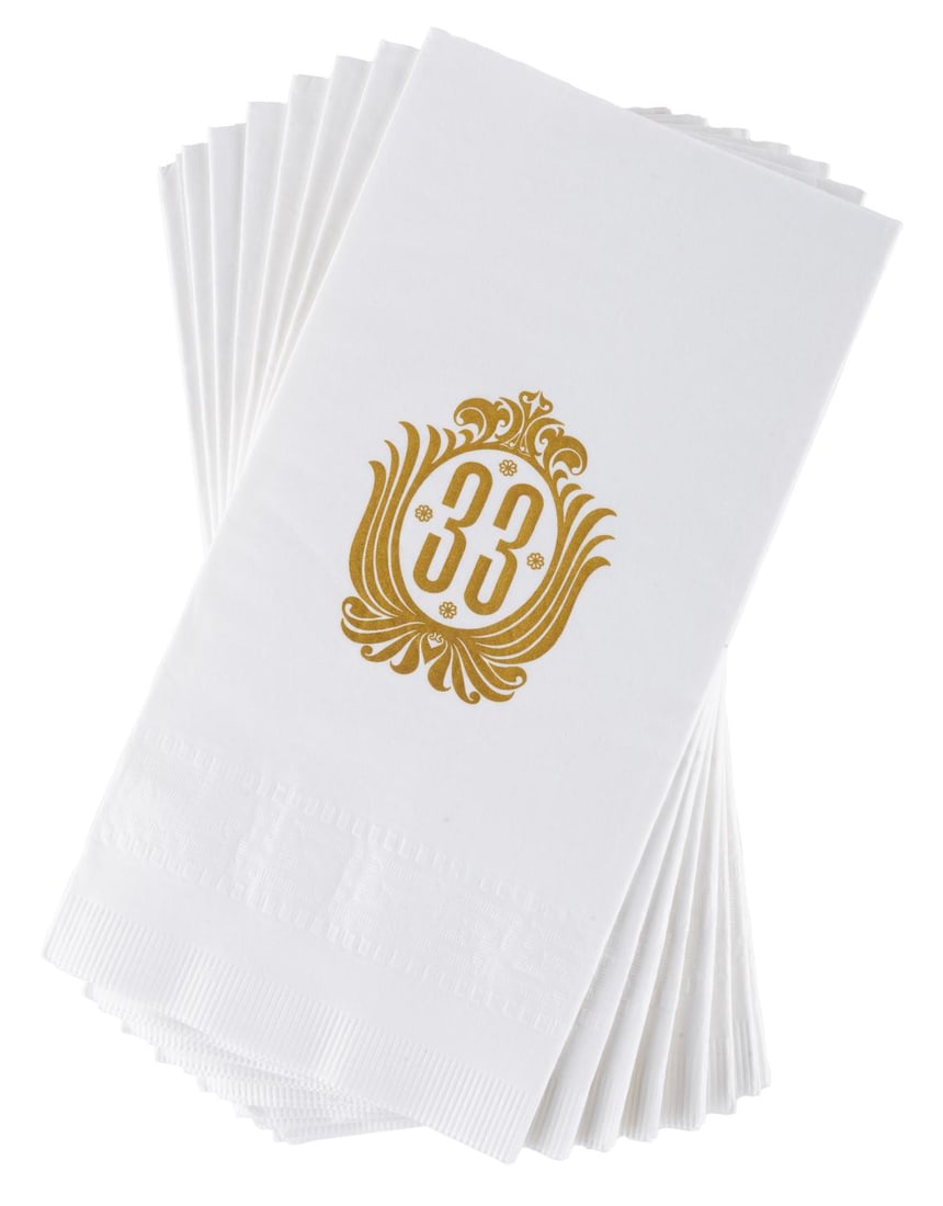 A Collection of Club 33 Paper Napkins.: (Disneyland, 2000s) A collection of eight Club 33 napkins featuring the members-only establishment's pre-2014 logo. Measuring 4.5" x 8.5" each, the paper napkins are in good to very good condition wit
