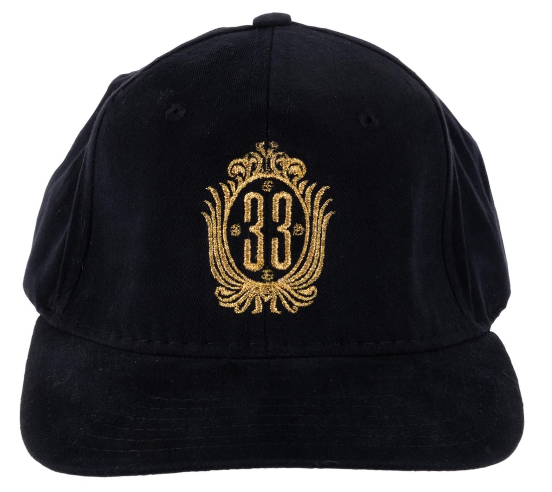 A Club 33 Logo Hat.: (Disneyland, 2000s) An embroidered baseball cap from the exclusive Club 33 featuring the logo in delicate gold. The one-size-fits-most hat is in fine condition.