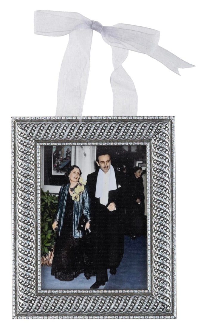 A Club 33 Walt and Lilian Photograph Ornament.: (Disneyland, 2000s) A framed photo-on-canvas ornament from Disneyland's exclusive Club 33. The image shows Walt and Lillian Disney in the 1930s leaving a movie premiere. Measuring 4.25" x 5.5", the or