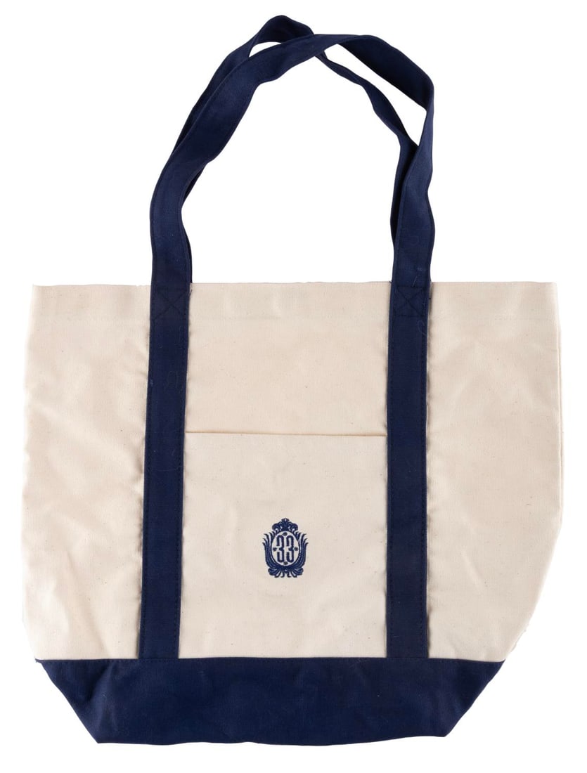 A Club 33 Canvas Tote Bag: (Disneyland, 2000s) A Club 33 canvas tote bag featuring the "33" logo embroidered on the front pocket. Measuring 15" x 17.5" the bag is in good condition with heavy oxidation to the metal snap closure