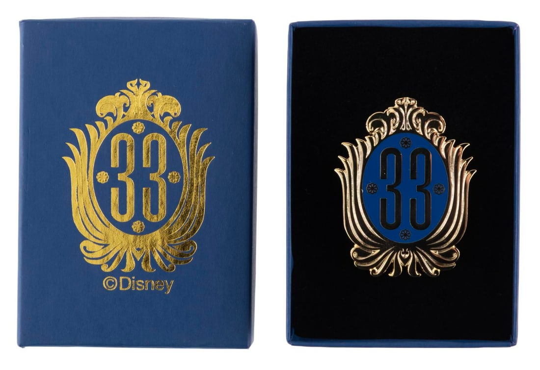 A Club 33 Logo Pin.: (Disneyland, 2013) A Club 33 pin from the year before the logo's redesign, sold exclusively at the members-only restaurant. Measuring 1.5" x 1.75", the pin comes with its original box and is in fine c