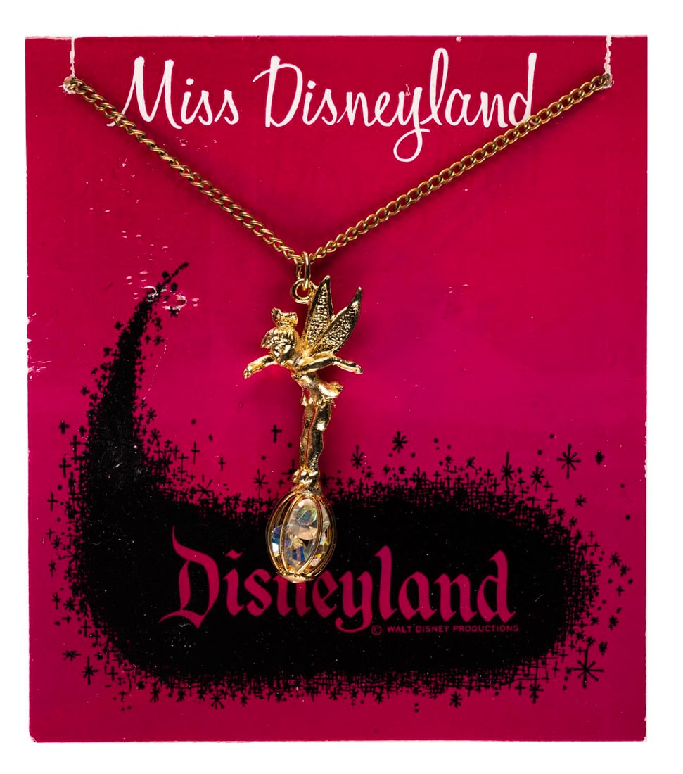 A Miss Disneyland Tinker Bell Necklace.: (Disneyland, 1955-70s) A Miss Disneyland Tinker Bell necklace with a charm of the fairy atop a small cage filled with four faux jewels. The charm measures 1.75" tall on a 16" necklace and is in very