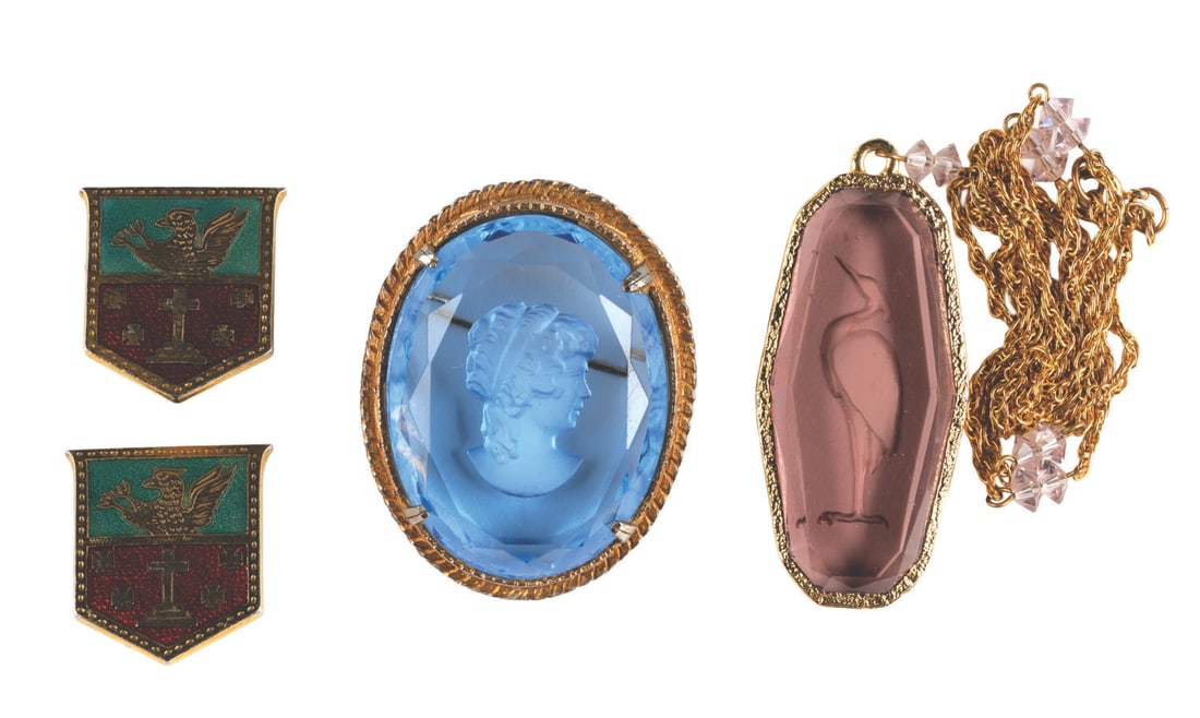 A Treasure Prop Collection from "The Goonies.": (Warner Bros., 1985) A collection of four props from One-Eyed Willy's treasure hoard in "The Goonies." Included are a light blue brooch featuring a relief of a woman's head, two cufflinks, and a