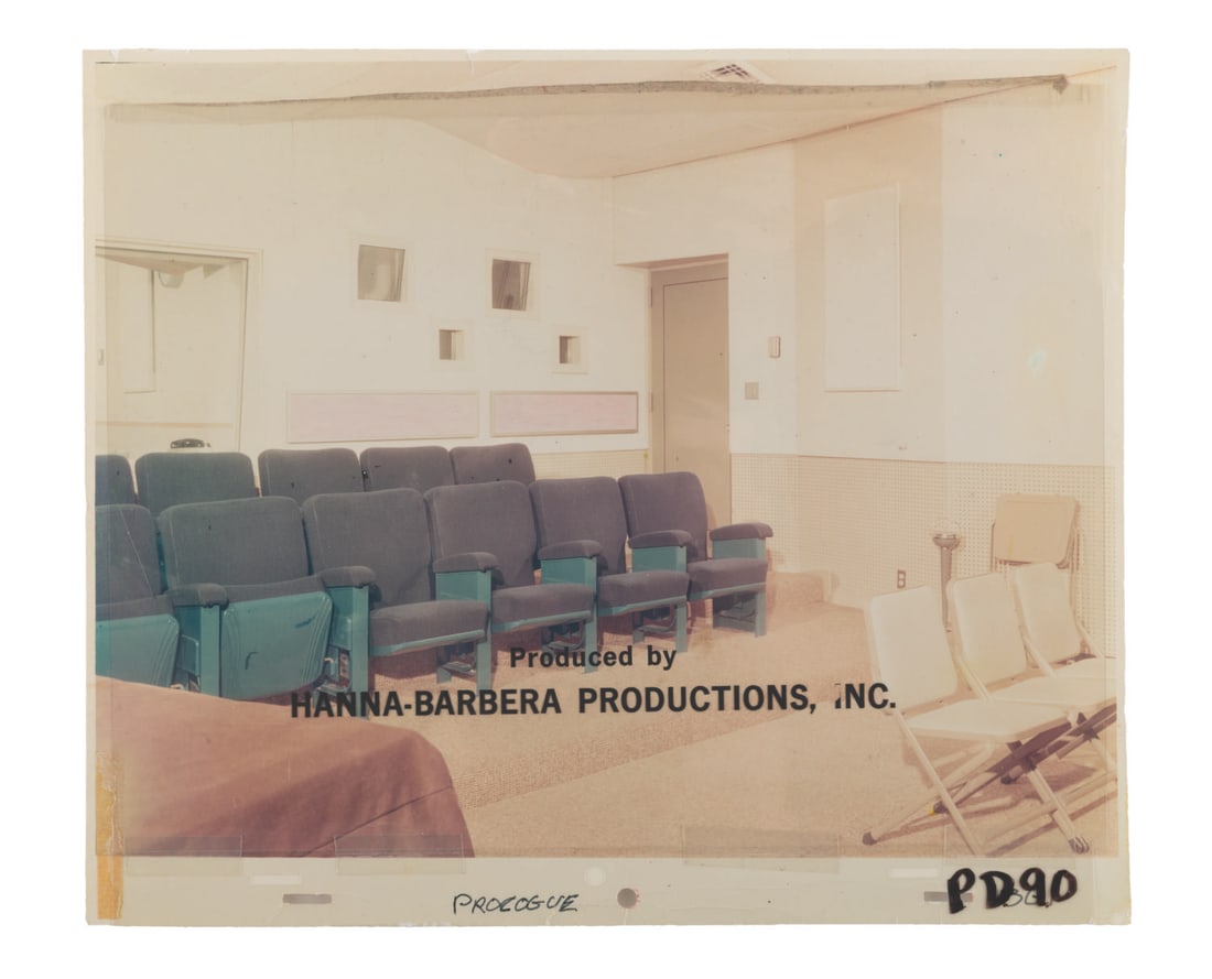 A Hanna-Barbera Title Cel & Screening Room Background.: (Hanna-Barbera, 1960s) An original hand-painted title cel and background photograph of Hanna-Barbera's screening room from the prologue of a 1960s production. The text has a size of 0.75" x 7.75" on