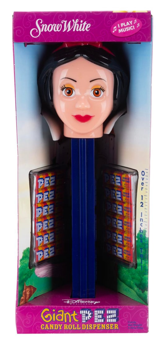 A Giant Snow White PEZ Dispenser.: (PEZ, 2006) A Giant Snow White PEZ Dispenser in the original package. The dispenser includes 12 packs of candy and is meant to play music when opened. The musical function has not been tested to prese